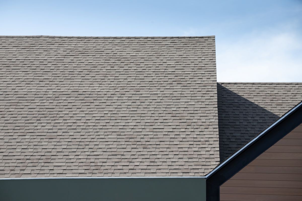 Roof shingles on top of the house against blue sky. dark asphalt tiles on the roof background, Wayzata
