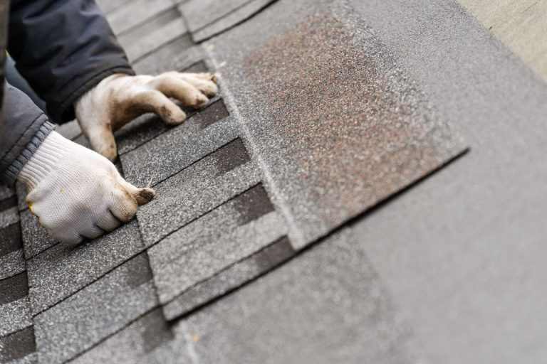 hand installing asphalt shingles on a roof, Wayzata, Minnesota